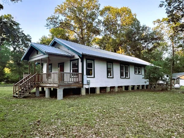 a front view of a house with a garden and deck