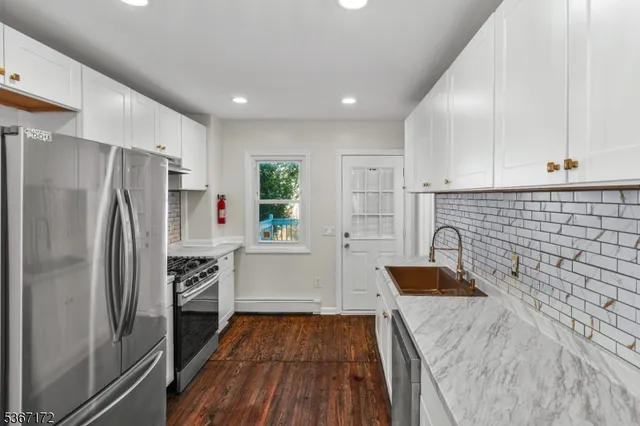 a kitchen with stainless steel appliances a refrigerator sink and stove