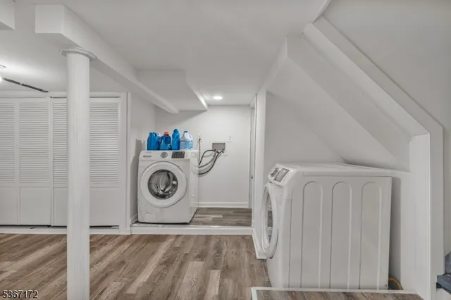 a view of washer and dryer with bathroom in the background