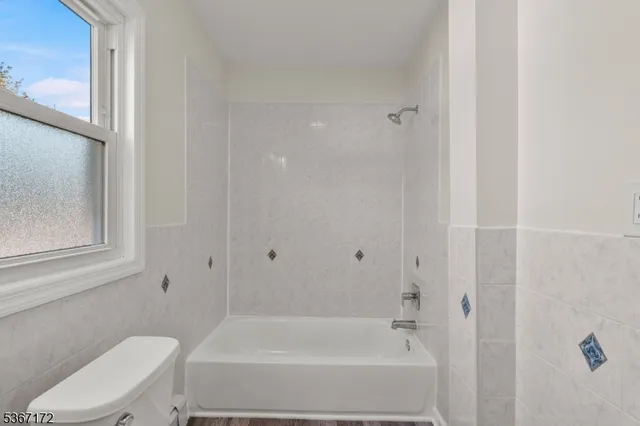 a white bath tub sitting next to a white toilet