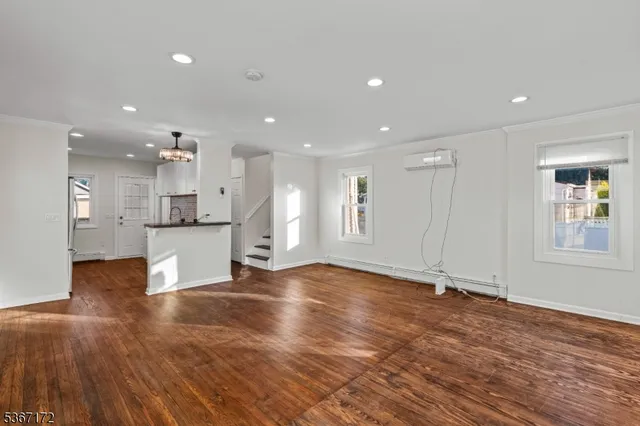 a view of an empty room with kitchen appliances and a window