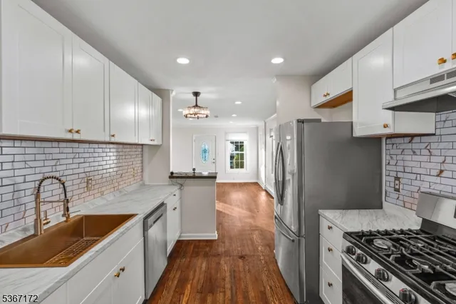 a kitchen with stainless steel appliances granite countertop a sink stove and refrigerator