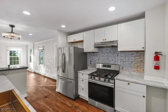 a kitchen with stainless steel appliances granite countertop a stove a refrigerator and a sink