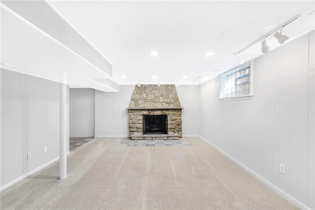 69 Holland Road Pittsburgh, PA 15235 - Photo 20 of 25 The 20x14 game room has a beautiful stone fireplace that is wood burning. The carpeting is new. Note that the window is glass block. There is ample space for a home theater or for family gatherings.