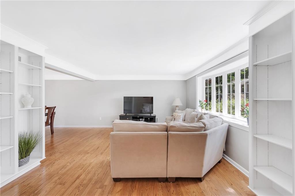 To the right is a large bow window that allows a great view and plenty of natural lighting.  Note the beautiful refinished wood floor in this 18x14 living room.
