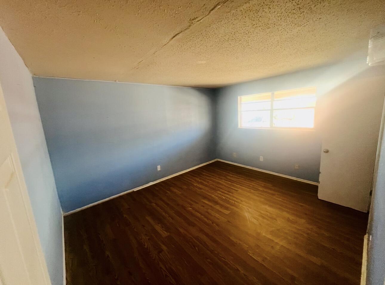 1510 29th Place Lubbock, TX 79411 - Photo 8 of 9 an empty room with wooden floor and windows