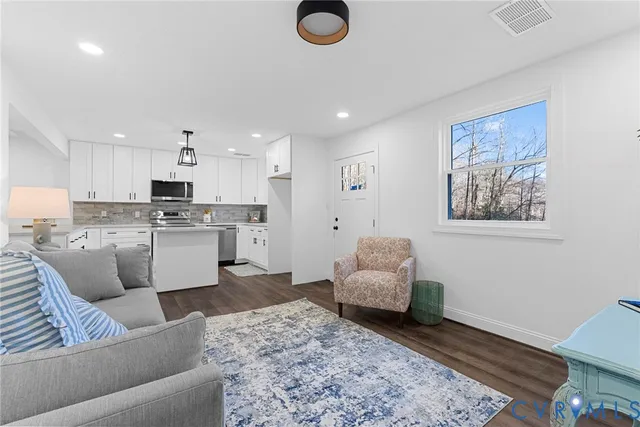 a living room with furniture and kitchen view