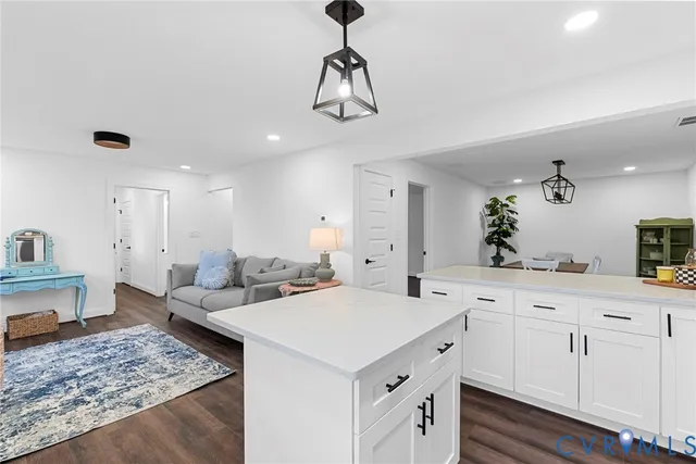 a view of center island kitchen island a sink a wooden floor and living room view
