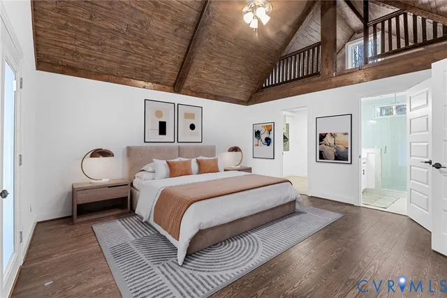 a spacious bedroom with a bed and wooden floor