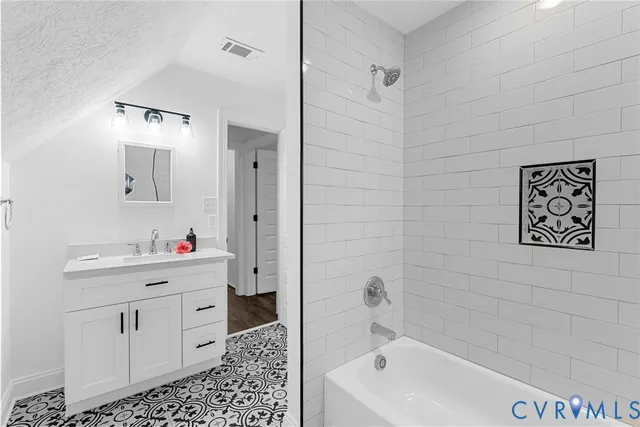 a bathroom with a bathtub sink mirror vanity and toilet
