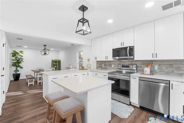 a kitchen with a sink a stove cabinets and wooden floor