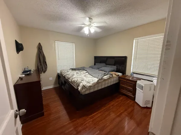 a bedroom with a bed and wooden floor