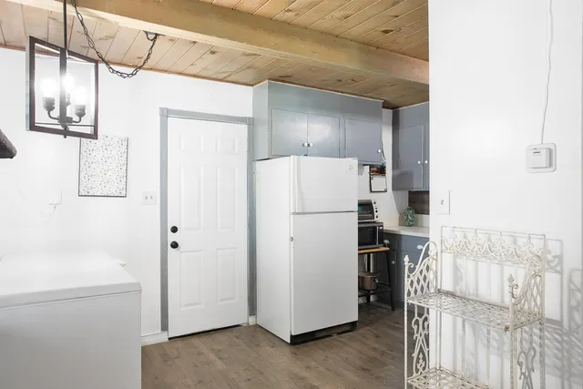 a view of hallway with wooden cabinets and refrigerator