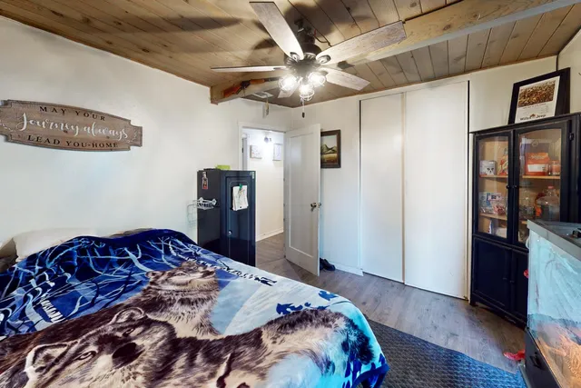 a bedroom with a bed and wooden floor