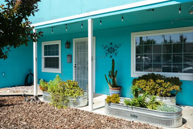 a front view of a house with potted plants