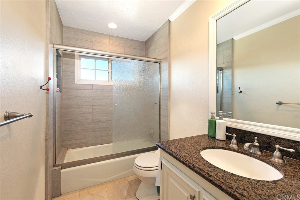 7 Windsor Newport Beach, CA 92660 - Photo 29 of 40 a bathroom with a granite countertop sink toilet mirror and shower