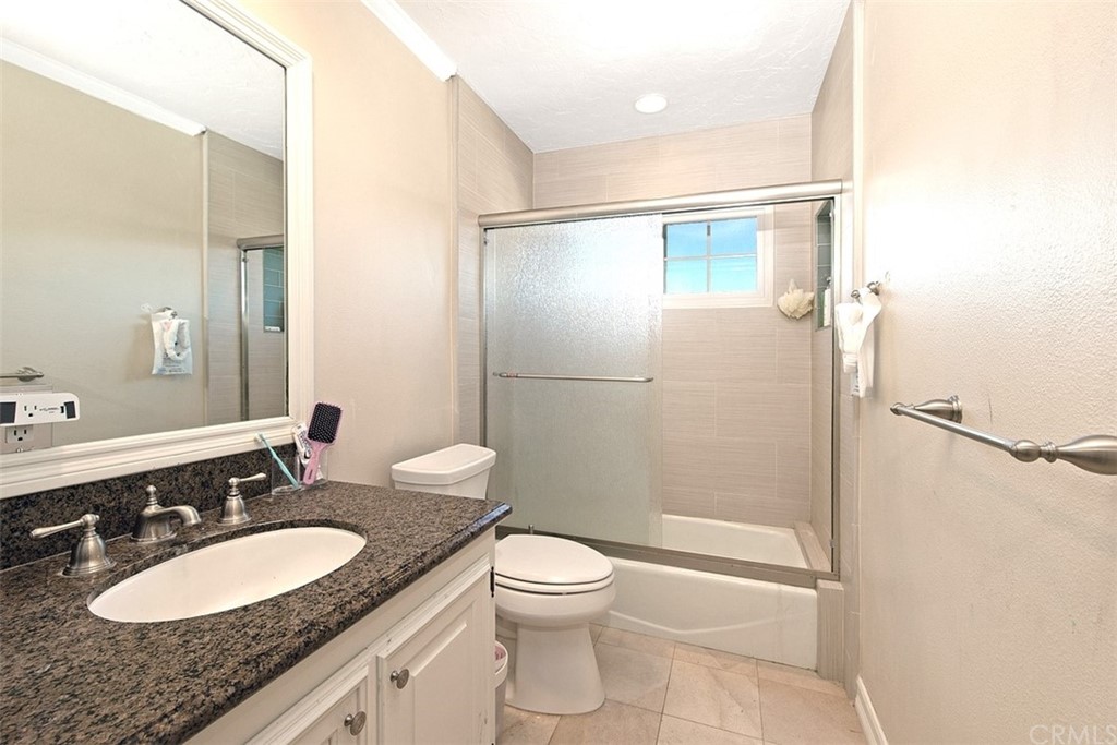 7 Windsor Newport Beach, CA 92660 - Photo 31 of 40 a bathroom with a granite countertop sink toilet a mirror and shower