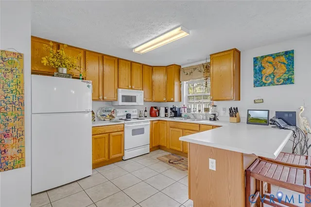 a kitchen with stainless steel appliances granite countertop a refrigerator a stove top oven a sink a dining table and chairs