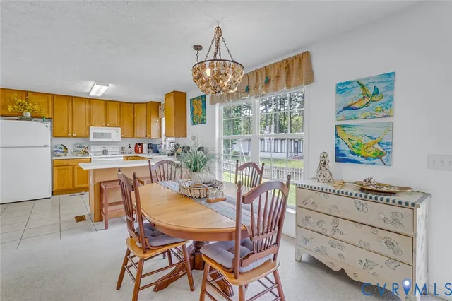 a dining room filled chandelier and kitchen view