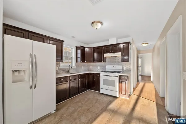 a kitchen with stainless steel appliances granite countertop a refrigerator stove and sink