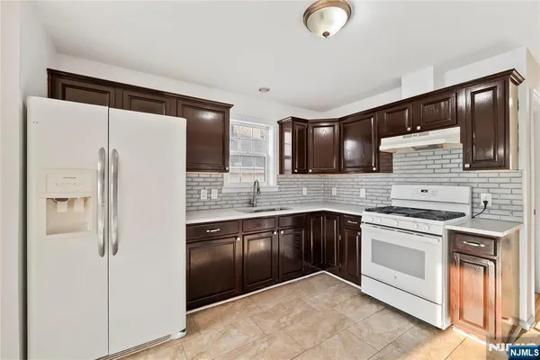 a kitchen with stainless steel appliances granite countertop a refrigerator and a stove top oven