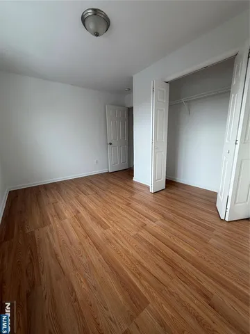 an empty room with wooden floor and door