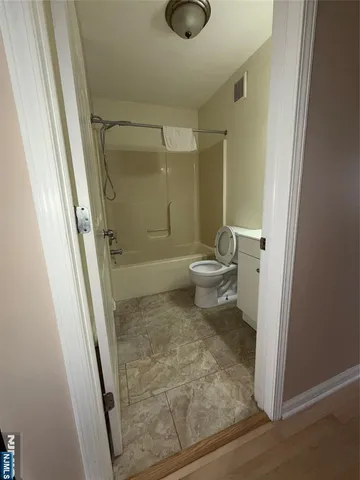 a bathroom with a granite countertop shower and a toilet