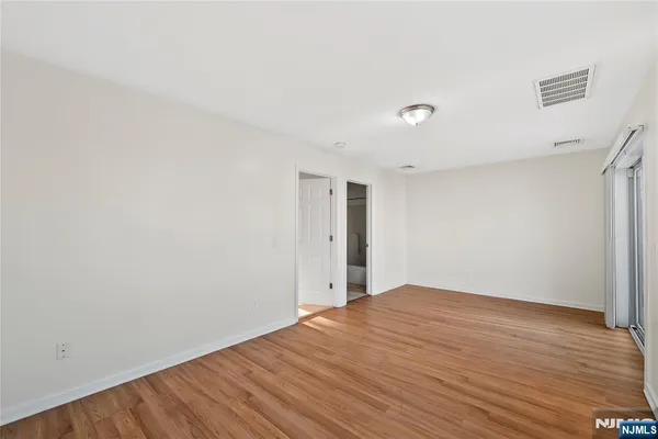 a view of an empty room with wooden floor