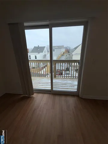 a view of a room with wooden floor and a window