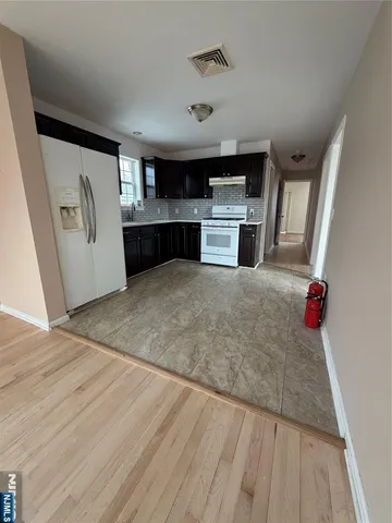 a view interior of kitchen and empty room with wooden floor