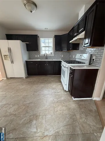 a large kitchen with stainless steel appliances granite countertop a stove a sink and a microwave