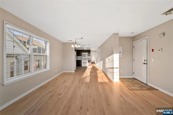 a view of empty room with wooden floor and windows