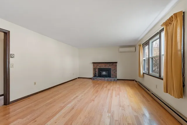 a view of an empty room with a fireplace and a window