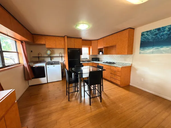 a view of kitchen with kitchen island dining table and wooden floor