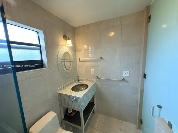 a bathroom with a toilet a sink and a mirror