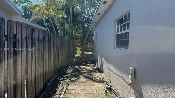 a view of a pathway of a house with wooden fence