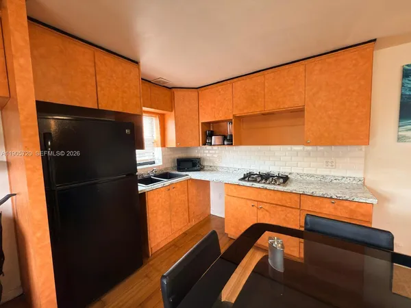 a kitchen with granite countertop a refrigerator stove and sink