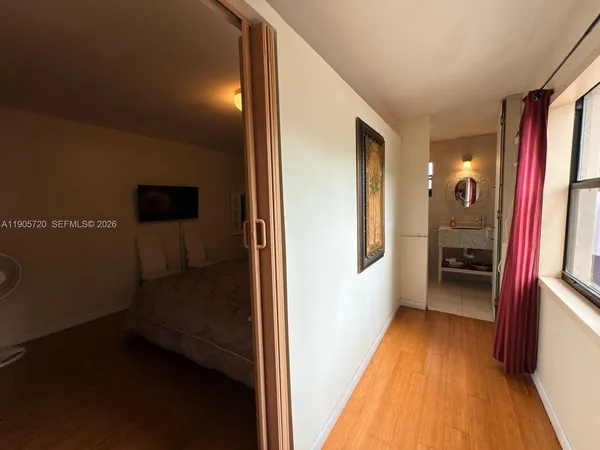 a view of a hallway with wooden floor and staircase