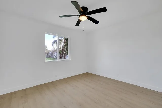 an empty room with closet and a ceiling fan