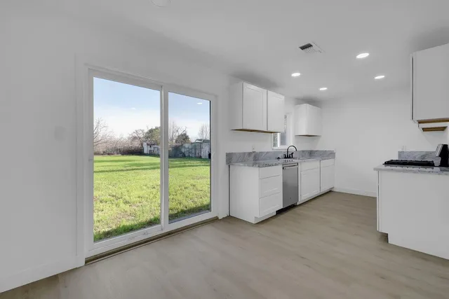 a kitchen with kitchen island white cabinets and white appliances
