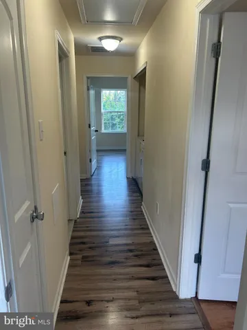 a view of a hallway with wooden floor and closet