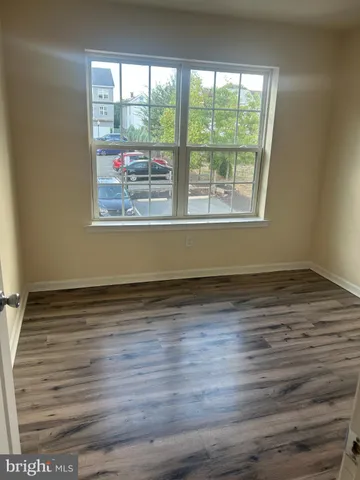 a view of a room with wooden floor and a window