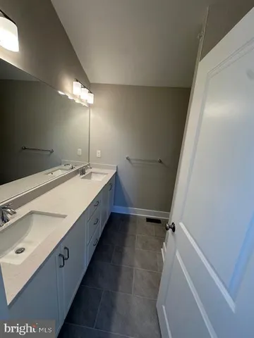 a spacious bathroom with a double vanity sink and mirror