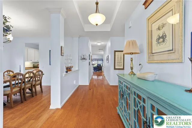 a dining room with furniture a chandelier and wooden floor