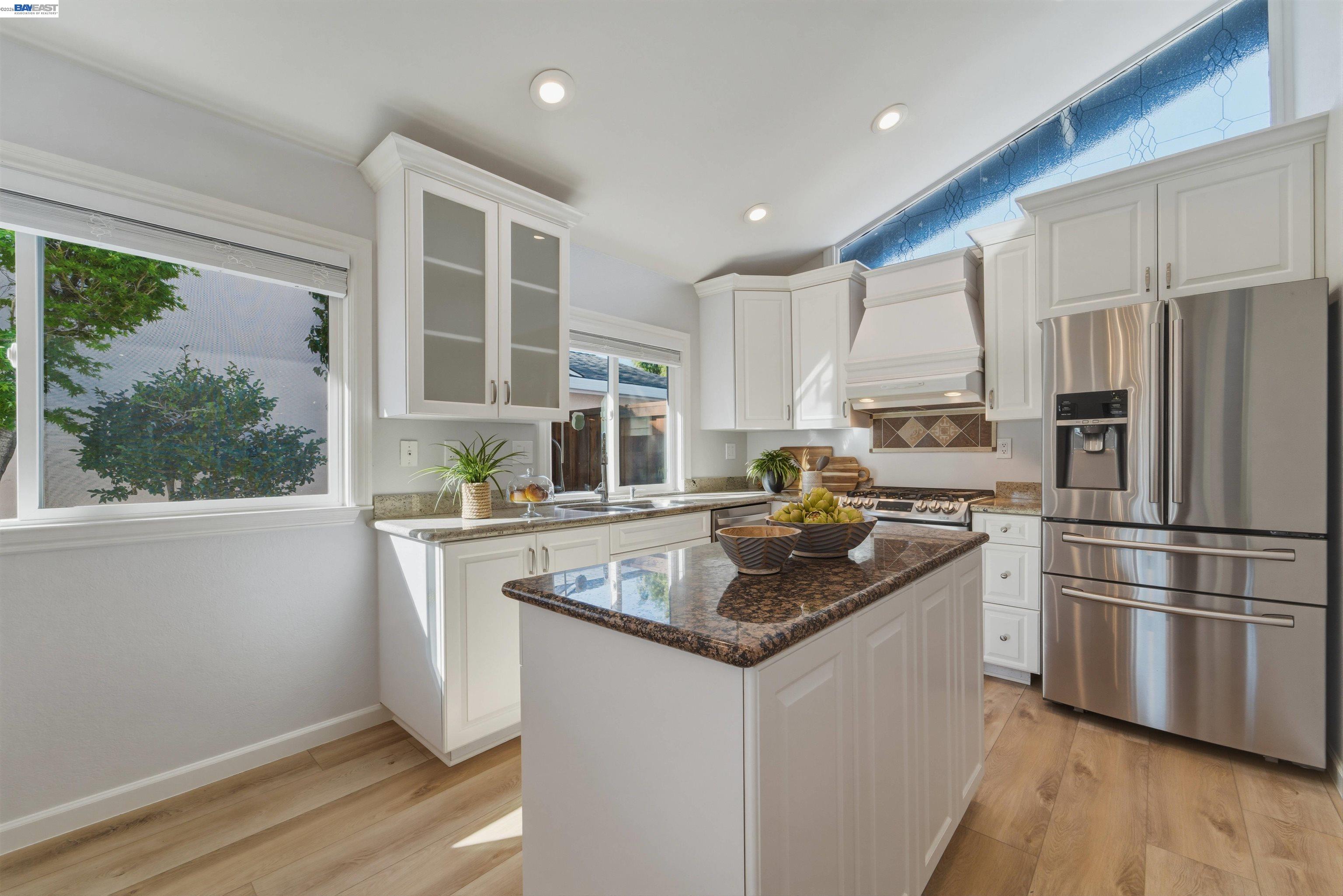 32471 Lake Ree Street Fremont, CA 94555 - Photo 5 of 31 a kitchen with stainless steel appliances granite countertop a refrigerator a sink a stove and white cabinets with wooden floor
