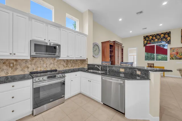 a kitchen with stainless steel appliances granite countertop a stove and a sink