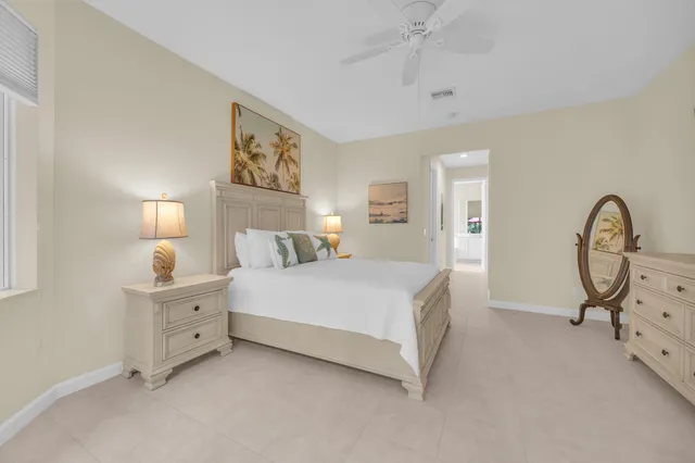 a bedroom with bed and a flat tv screen on dresser
