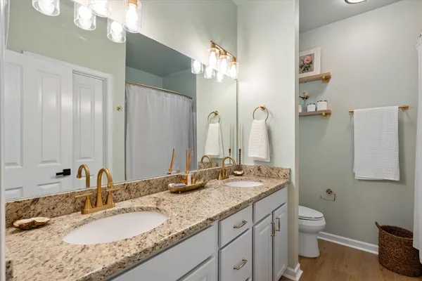 a bathroom with a granite countertop double vanity sink and a mirror