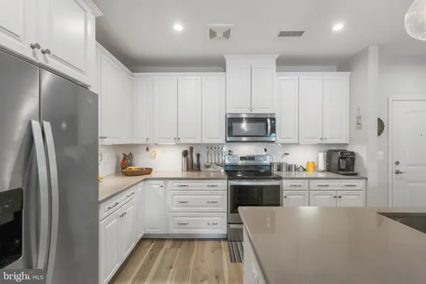 a kitchen with stainless steel appliances a refrigerator sink and cabinets