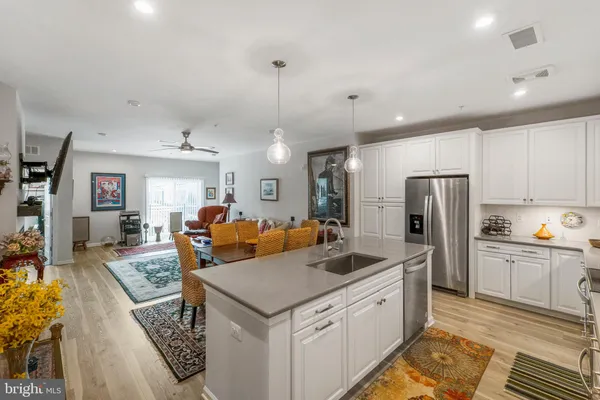 a kitchen with stainless steel appliances granite countertop a sink refrigerator and cabinets